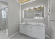 Thumbnail 3 of 17 - A white bathroom with a double sink vanity and a large mirror.