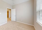 Thumbnail 15 of 17 - an empty bedroom with a closet and a door to a hallway