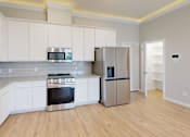 Thumbnail 13 of 17 - a kitchen with white cabinets and a stainless steel refrigerator