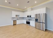 Thumbnail 16 of 17 - a kitchen with white cabinets and a stainless steel refrigerator