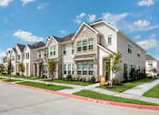 Thumbnail 1 of 17 - a row of town homes on a street with sidewalks and grass