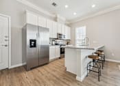 Thumbnail 8 of 17 - a large kitchen with stainless steel appliances and a bar with stools