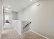 Thumbnail 4 of 17 - an empty basement with a stairway and white walls and carpet