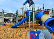 Thumbnail 27 of 27 - A playground with a blue slide and a grey elephant toy.