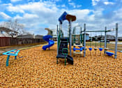 Thumbnail 26 of 27 - A playground with a blue slide and a green climbing frame.