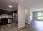 Thumbnail 12 of 20 - an empty living room with a kitchen in the background