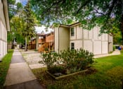 Thumbnail 9 of 10 - a sidewalk between two buildings with trees and grass