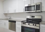 Thumbnail 6 of 12 - A modern kitchen with a stainless steel dishwasher and oven.