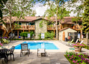 Thumbnail 8 of 10 - a swimming pool in front of a house with a pool table and chairs