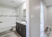 Thumbnail 12 of 16 - an empty bathroom with a toilet and a sink and a shower
