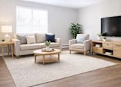 Thumbnail 3 of 27 - A living room with a white couch, a wooden coffee table, and a flat-screen TV.
