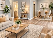Thumbnail 1 of 27 - A living room with a couch, coffee table, and dining area.