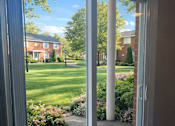 Thumbnail 9 of 27 - A view of a backyard through a sliding glass door.