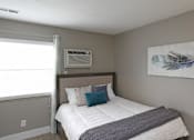 Thumbnail 11 of 14 - A bedroom with a bed, pillows, and a painting on the wall.