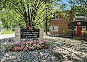 Thumbnail 4 of 12 - A sign for Colonial Square Apartment Homes is in front of a brick building.