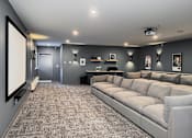 Thumbnail 12 of 16 - A spacious living room with a grey sofa and a large screen on the left side.