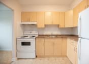 Thumbnail 2 of 21 - an empty kitchen with white appliances and wooden cabinets