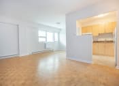 Thumbnail 9 of 21 - an empty living room and kitchen with wood flooring