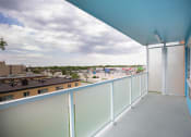 Thumbnail 15 of 21 - a balcony with a view of a city and a cloudy sky