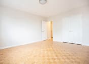 Thumbnail 11 of 21 - an empty living room with a wooden floor and white doors