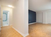 Thumbnail 8 of 21 - an empty living room with wood flooring and a blue accent wall