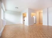 Thumbnail 6 of 21 - an empty living room and kitchen with a wood floor