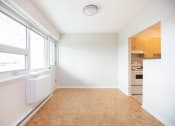 Thumbnail 5 of 21 - a empty living room with a window and a kitchen