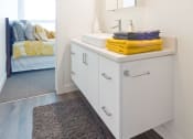 Thumbnail 9 of 18 - a bathroom with white cabinets and a white sink with a mirror above it