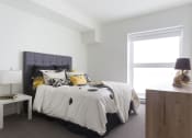 Thumbnail 13 of 18 - a bedroom with white walls and a large bed with black and yellow bedding