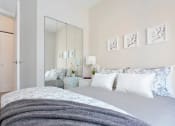 Thumbnail 17 of 31 - a white bedroom with a bed and a mirror