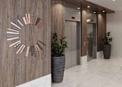 Thumbnail 23 of 30 - A wooden wall with a circular decoration and two potted plants.