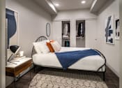 Thumbnail 20 of 30 - A bedroom with a bed, a nightstand, and a rug.