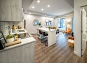 Thumbnail 6 of 30 - A modern kitchen with a white countertop and wooden flooring.