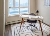 Thumbnail 10 of 30 - A room with a desk and chair in front of a large window.