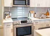 Thumbnail 16 of 30 - A modern kitchen with a stainless steel oven and microwave above it.