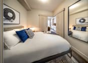 Thumbnail 14 of 30 - A bedroom with a large bed and a mirror on the wall.