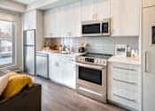 Thumbnail 12 of 30 - A modern kitchen with stainless steel appliances and wooden cabinets.