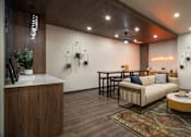 Thumbnail 7 of 30 - A living room with a white couch and a coffee table.