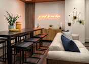 Thumbnail 25 of 30 - A room with a long table and a couch with a blue pillow.
