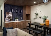 Thumbnail 24 of 30 - A modern kitchen with a wooden counter and a grey couch.