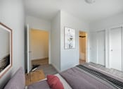 Thumbnail 2 of 30 - A bedroom with a bed and a painting on the wall.