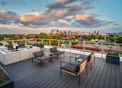 Thumbnail 30 of 30 - A wooden deck with a table and chairs overlooking a city skyline.
