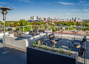 Thumbnail 29 of 30 - A rooftop patio with a view of the city skyline.