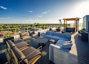 Thumbnail 27 of 30 - A rooftop patio with a table and chairs.