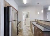 Thumbnail 29 of 31 - a kitchen with a stainless steel refrigerator and counter tops