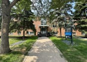 Thumbnail 1 of 15 - a brick building with trees in front of it