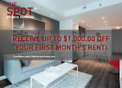 Thumbnail 1 of 18 - A living room with a white sofa and a sign offering up to $1,000 off the first month's rent.