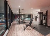 Thumbnail 18 of 18 - a gym with glass walls and a workout area with chairs and equipment