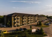 Thumbnail 4 of 31 - a large apartment building with a parking lot in front of it