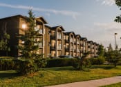 Thumbnail 3 of 31 - an apartment complex with a sidewalk and trees in the foreground